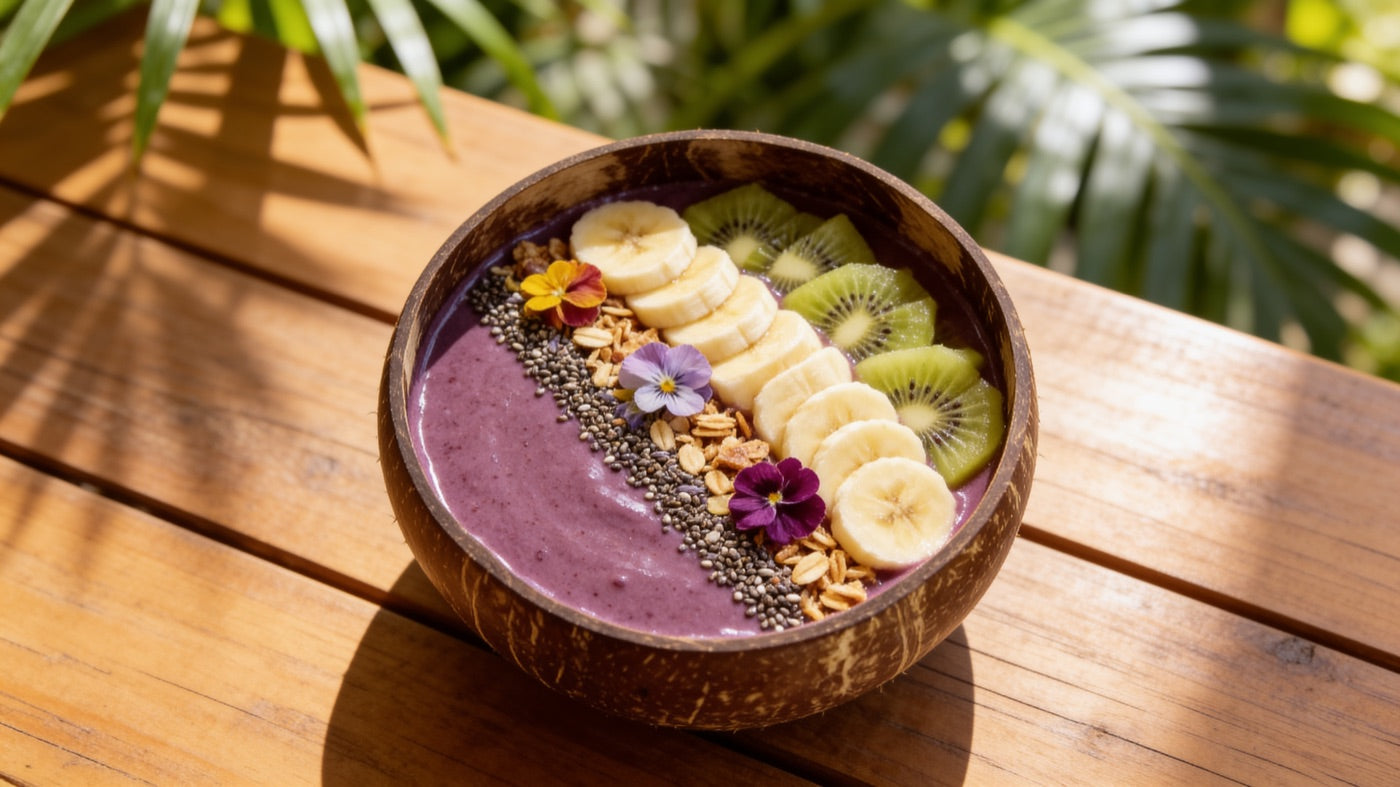 Coconut bowl filled with an açaí smoothie topped with banana, kiwi and granola